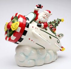 a santa clause riding on top of a white snow covered sleigh ornament