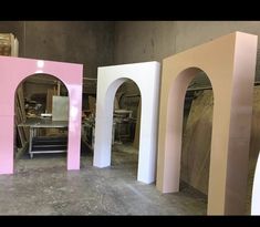 three different colored arches sitting in a room next to each other on the cement floor