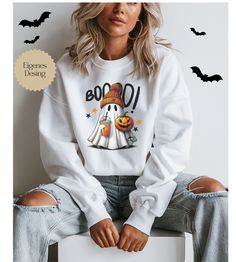 Cute Ghost Halloween Sweatshirt - The perfect cozy spooky look! Add a playful and cozy touch to your Halloween wardrobe with our cute Ghost Halloween Sweatshirt! This high-quality, comfortable sweatshirt is made from soft, breathable fabric that will keep you warm while you celebrate the spooky season in style. The charming ghost design is guaranteed to make you and your friends smile and provide plenty of Halloween fun. Whether you're attending a Halloween party, trick-or-treating, or just want White Fun Sweater For Fall, Fun White Sweater For Fall, White Cartoon Print Sweater For Fall, Spooky Halloween Crew Neck Sweater, Casual White Sweatshirt For Halloween, White Cartoon Print Sweatshirt For Fall, White Sweatshirt With Character Print For Fall, White Long Sleeve Halloween Sweatshirt, White Graphic Print Sweatshirt For Halloween