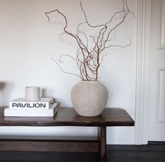 a table with a vase and some books on it