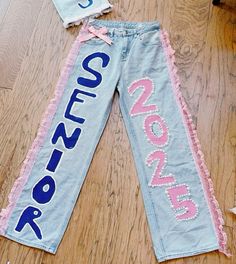 a pair of jeans with the word cut off on them sitting on top of a wooden floor