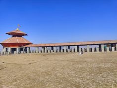 a large building sitting on top of a dry grass field