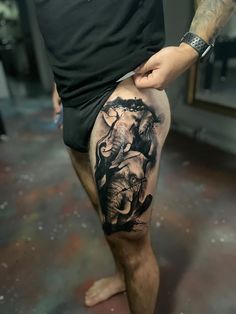 a man with an elephant tattoo on his leg