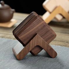 a wooden object sitting on top of a table next to a potted teapot