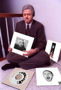 a man sitting on the floor holding up two cds and an album in front of him