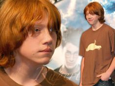 a boy with red hair and glasses standing in front of a movie poster wearing a brown t - shirt