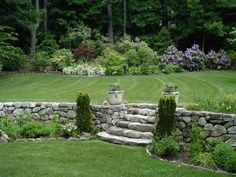 a stone wall in the middle of a garden