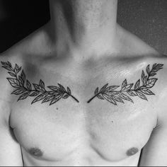 a man's chest with an arrow and leaves tattoo on his left side shoulder