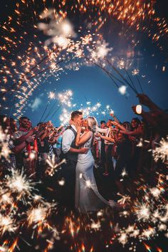 a newly married couple kissing in front of fireworks