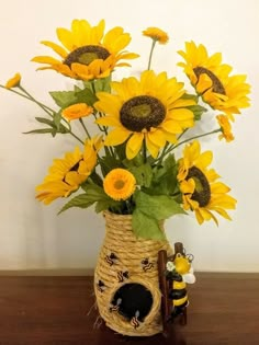 a vase filled with sunflowers on top of a wooden table