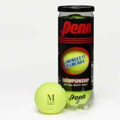 two tennis balls sitting next to a can of demn