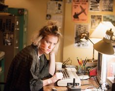 a woman sitting at a desk with a keyboard and mouse in front of her face