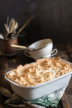 a casserole dish on a table with utensils