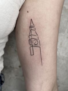 a small black and white tattoo of a clock tower