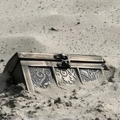 an old wooden box sitting in the sand