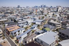 an aerial view of a city with many houses in the foreground and skyscrapers in the background