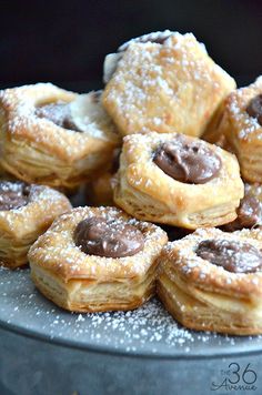 a pile of chocolate filled pastries sitting on top of a metal pan