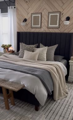 a large bed sitting in a bedroom next to two pictures on the wall above it