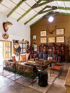 a living room filled with lots of furniture next to a book shelf and bookshelf