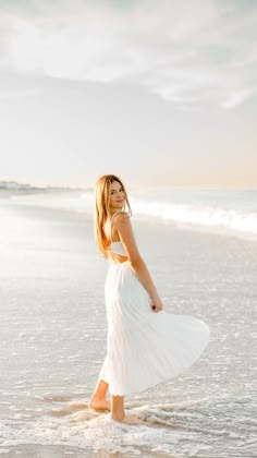 Girl wearing white dress standing in ocean at sunset Light Blue Senior Pictures, Beach Pictures Portrait, Poses By The Beach, Professional Beach Photos, Beach Photoshoot Portraits, Beach Senior Session, Photo Ideas For The Beach, Senior Pictures With Cap, Senior Beach Poses