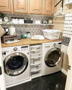 a washer and dryer in a small room with wooden cabinets on the wall