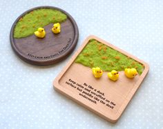 a wooden plaque with some little yellow rubber ducks on it next to a small brochure