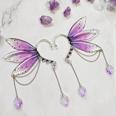 In search of an outstanding accessory to complete your favorite magical outfit? Our fairy inspired ear cuffs will guide you right into a world made of dreams! They are perfect for fashion photo shoots, cosplay or fantasy LARP. And the best thing about it? You do not need piercings to wear them! Just slide them over your outer ear behind the auricle and it stays there.  Available as single ear cuffs for either left or right and as a pair for both ears.  They do fit for average adult sized ears. Please note: They can not be adjusted in size. Also available with golden frames and with wings in blue, green and red. Please visit our shop for more. Creators recommendations: ★ The color of the wings pop best when the ear cuffs are worn on white/silver, light blonde or pastel colored hair ★ Wearin Fantasy Jewelry Magic, Outer Ear, Fairy Ears, Fantasy Earrings, Pretty Jewelry Necklaces, Magical Jewelry, Fairycore Cottagecore, Fairy Wings, Fancy Jewelry