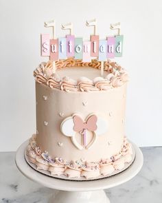 a birthday cake with pink frosting and decorations