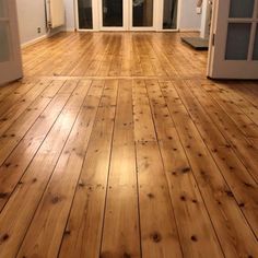 an empty room with hard wood floors and french doors leading to the front door area