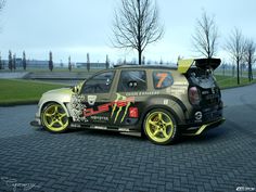 a small car with yellow rims parked on the street