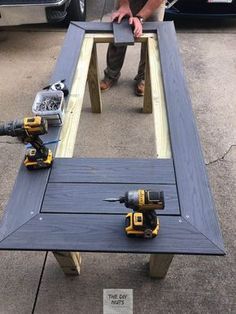 a table made out of wood with two drillers on it and a man in the background