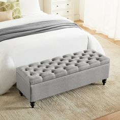 a bed with a gray bench on top of it