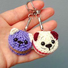 two crocheted keychains in the shape of dogs are being held by someone's hand