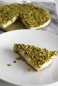 a white plate topped with a piece of cake covered in green sprinkles