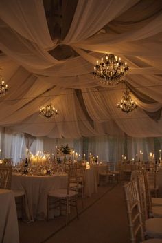 a banquet hall with chandeliers, tables and chairs