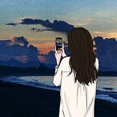 a woman standing on the beach taking a picture with her cell phone at sunset or dawn