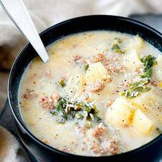 a bowl of soup with meat, potatoes and broccoli in it on a table