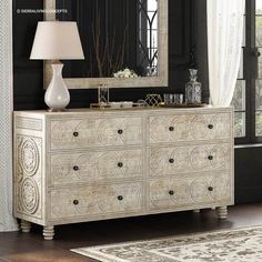 a white dresser sitting in front of a mirror