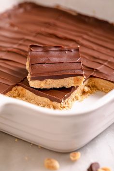 chocolate bars with peanut butter on top in a white dish, ready to be eaten