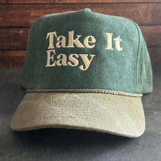 Vintage Style Take It Easy Embroidered Faded Canvas Snapback Trucker Rope Hat with Free Shipping. White stitched text/logo. Condition is "New with tags". Shipped with USPS First Class. Step into the world of the great outdoors with our Take It Easy Stitched Faded Canvas Rope Hat. With its faded canvas and rope accents, this hat exudes rustic charm. Plus, enjoy free shipping on this perfectly vintage-inspired accessory. *Condition is "New with tags". Shipped with USPS First Class. *This is a medi Vintage Letter Print Snapback Hat For Outdoor, Vintage Snapback Hat With Letter Print For Outdoor, Vintage Green Baseball Cap With Embroidered Logo, Vintage Curved Brim Hat With Letter Embroidery, Vintage Outdoor Baseball Cap With Embroidered Logo, Vintage Adjustable Hat With Letter Embroidery, Embroidered Trucker Hat, Rope Hats, Take It Easy