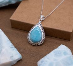 Embrace sophistication with our Pear-Shaped Silver Pendant, a stunning piece adorned with a central Larimar teardrop and framed by delicate, sparkling Blue Topaz accents meticulously nestled within small silver triangles. This exquisite pendant is a testament to elegance and grace. Elegant Design: The pear-shaped pendant features a captivating Larimar teardrop at its heart, exuding tranquility and beauty. Encircling the serene Larimar, a meticulously crafted silver frame adorned with intricate triangular settings cradles tiny Blue Topaz stones, adding a touch of shimmer and sophistication. Crafted Sophistication: Meticulously crafted in sterling silver, this pendant showcases meticulous attention to detail. The arrangement of the Blue Topaz stones in a triangular pattern not only complemen Aquamarine Gemstone Bead Jewelry As Gift, Aquamarine Gemstone Beads Jewelry As Gift, Blue Larimar Jewelry With Gemstone Beads, Spiritual Larimar Pendant Jewelry, Aquamarine Jewelry Gift, Aquamarine Stone Jewelry Gift, Larimar Gemstone Bead Necklaces For Gifts, Larimar Gemstone Beads Necklace As Gift, Larimar Gemstone Beads Necklace For Gift