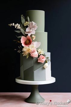 a three - tiered cake with flowers on the top and bottom layer is green