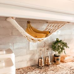 a banana hanging in a hammock over a kitchen counter