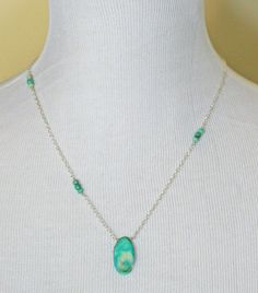 "A druzy focal in a dreamy shade of light green with subtle undertones of teal is united with a simple silver chain accented with faceted Chrysoprase gemstones. The druzy is fixed simply to the silver chain letting its beauty be the highlight. It has a sparkling druse of white crystals in the center that shine on naturally. even the back of the druzy is lovely, looking like a wave in the sea. The necklaces is finished with more Chrysoprase and a lobster claw clasp. Necklace is 20 inches long. Th Sterling Silver Turquoise Faceted Necklace, Necklace Green Stone, Ocean Jasper Necklace, Asymmetrical Necklace, Geode Necklace, Green Stone Necklace, Druzy Necklace, Jasper Necklace, Clasp Necklace