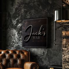 a brown leather chair sitting in front of a wall with a jack's bar sign on it