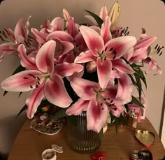 a vase filled with pink flowers sitting on top of a table next to other items