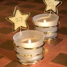 two white candles sitting next to each other on a table