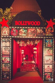 an entrance to a movie theater with red carpet and hollywood posters on the wall behind it