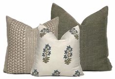 three pillows with different patterns on them, one in grey and the other in white