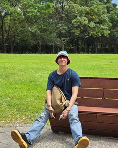 a man sitting on top of a wooden bench